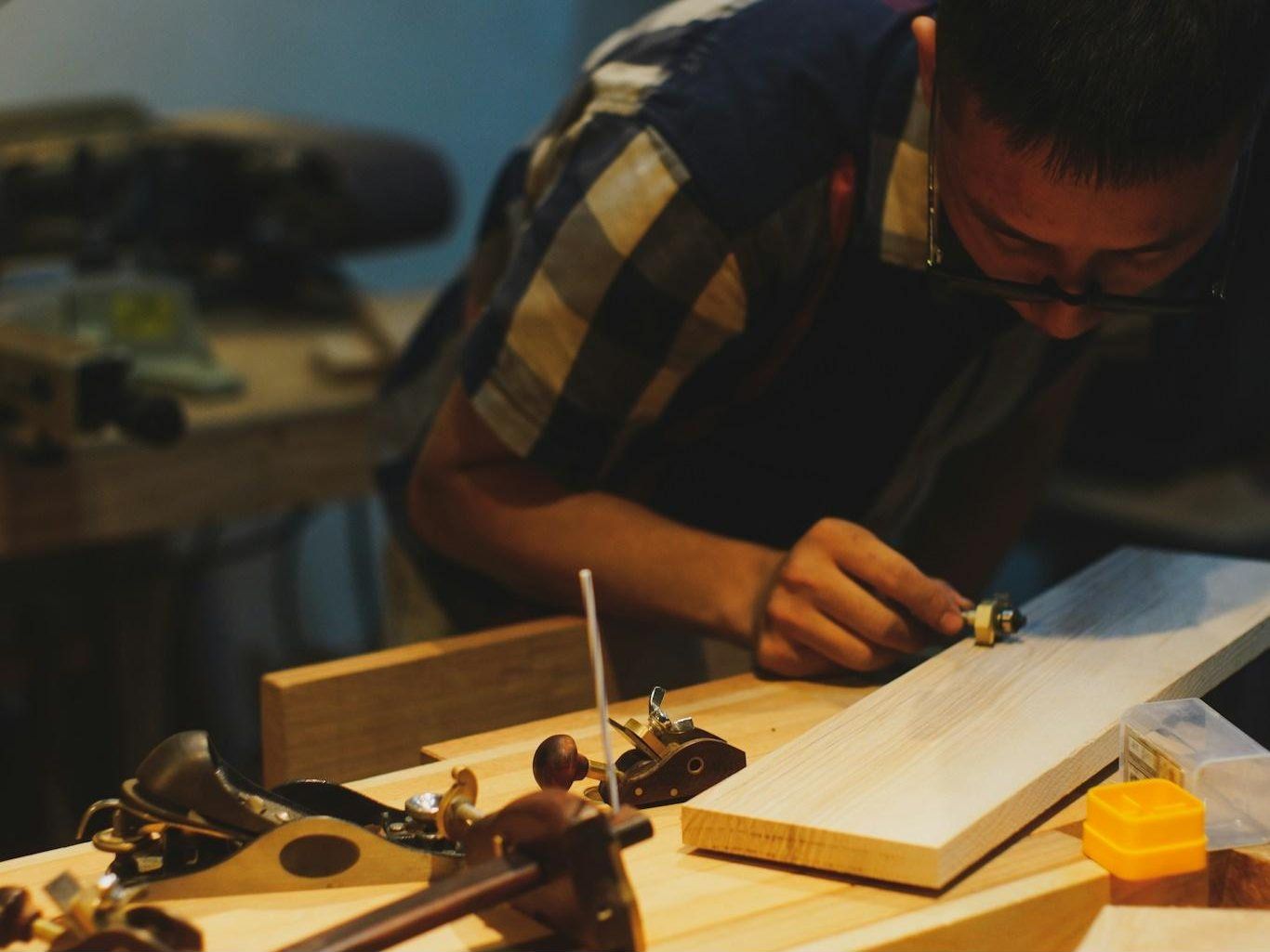 Carpenter measuring timber in a workshop